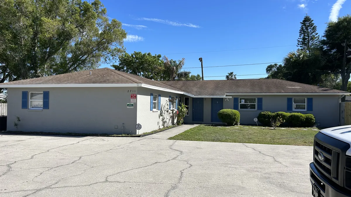 A freshly painted single story Florida home with a clean lawn out front